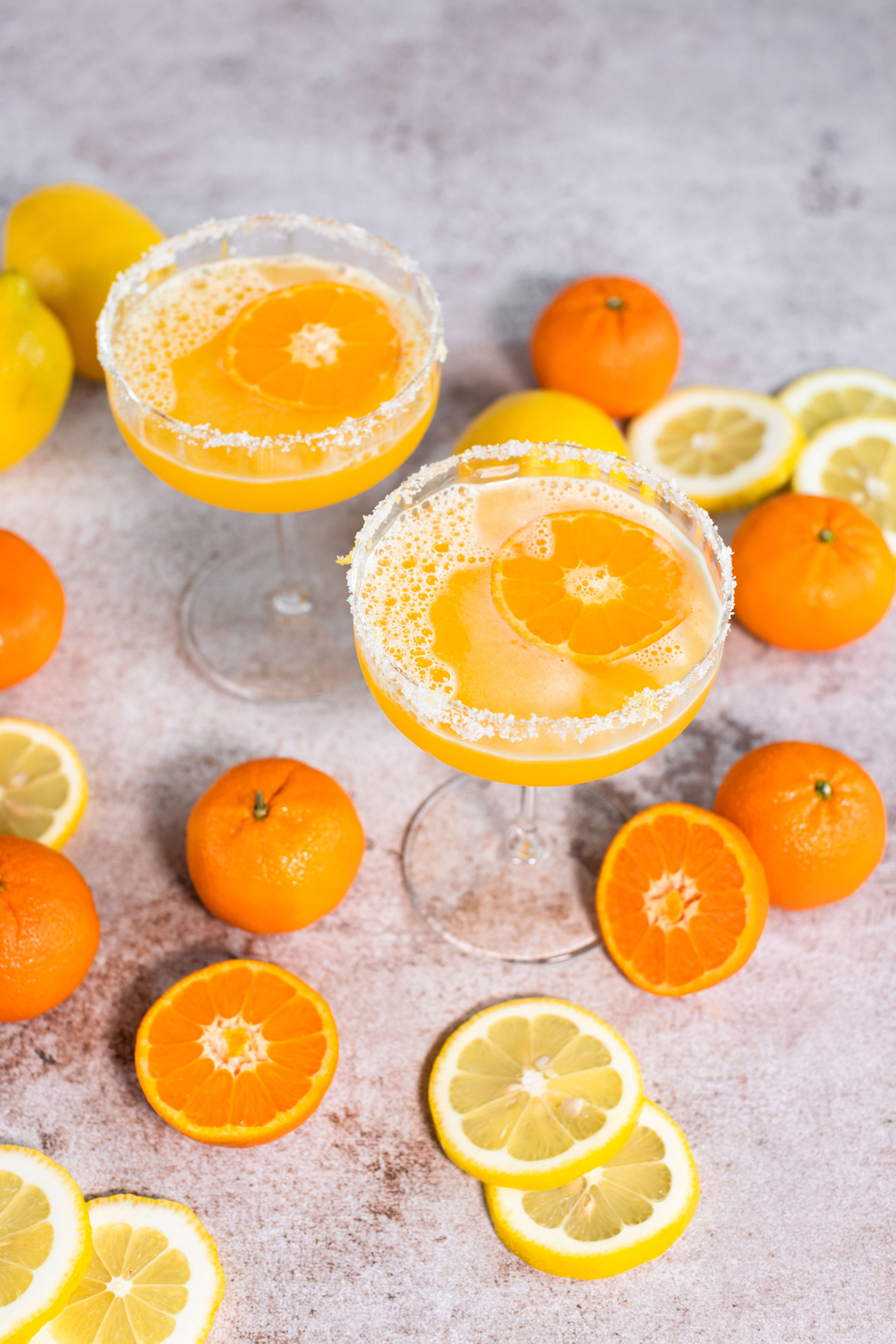 PCN mandarin lemon drop with mandarins and lemons surrounding the glass